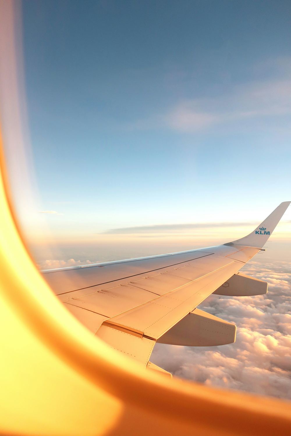 Sunset view from an airplane window seat above the clouds